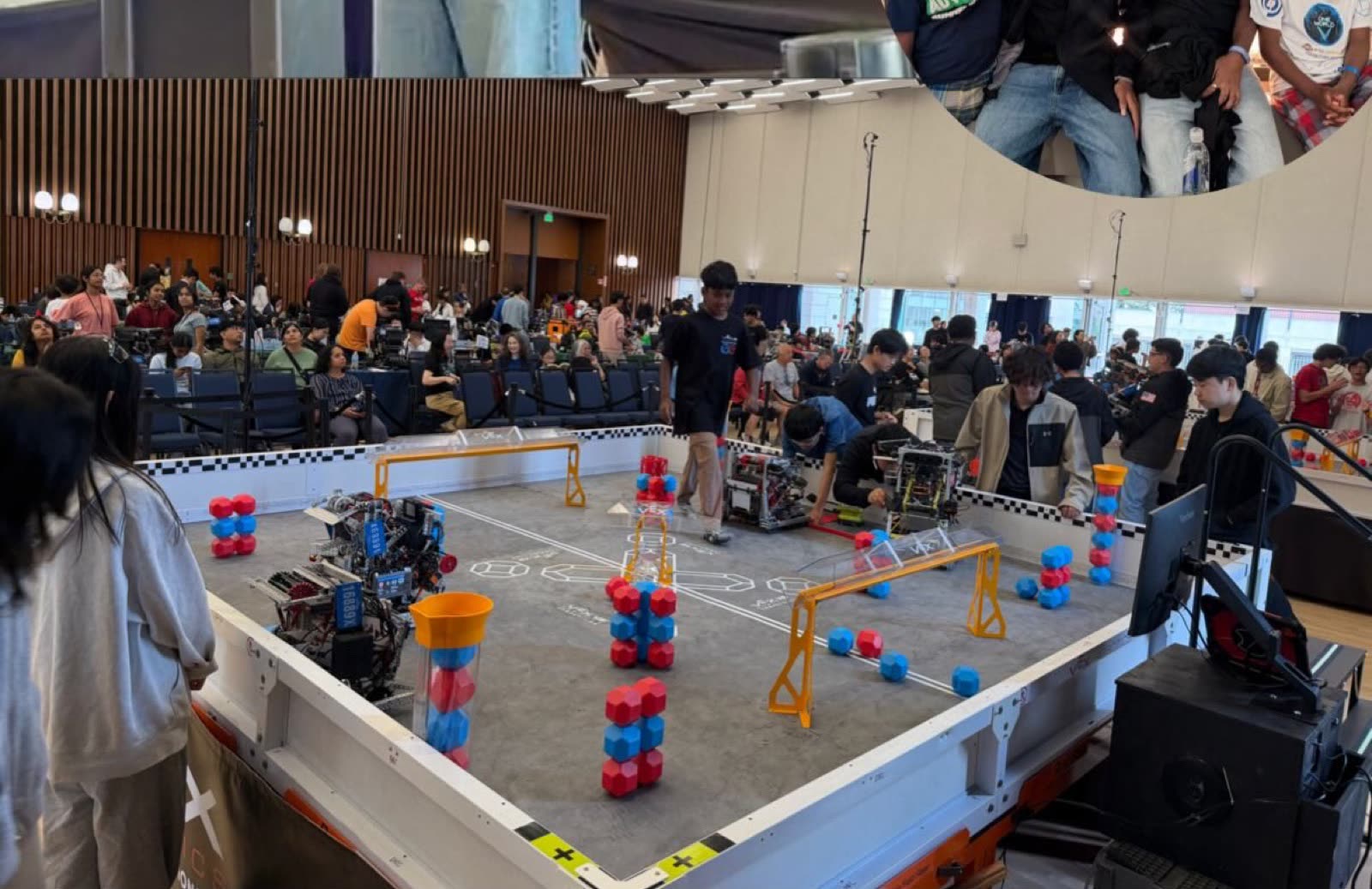 Fully autonomous robots on the field at the VEX AI World Championship, spectators around the perimeter