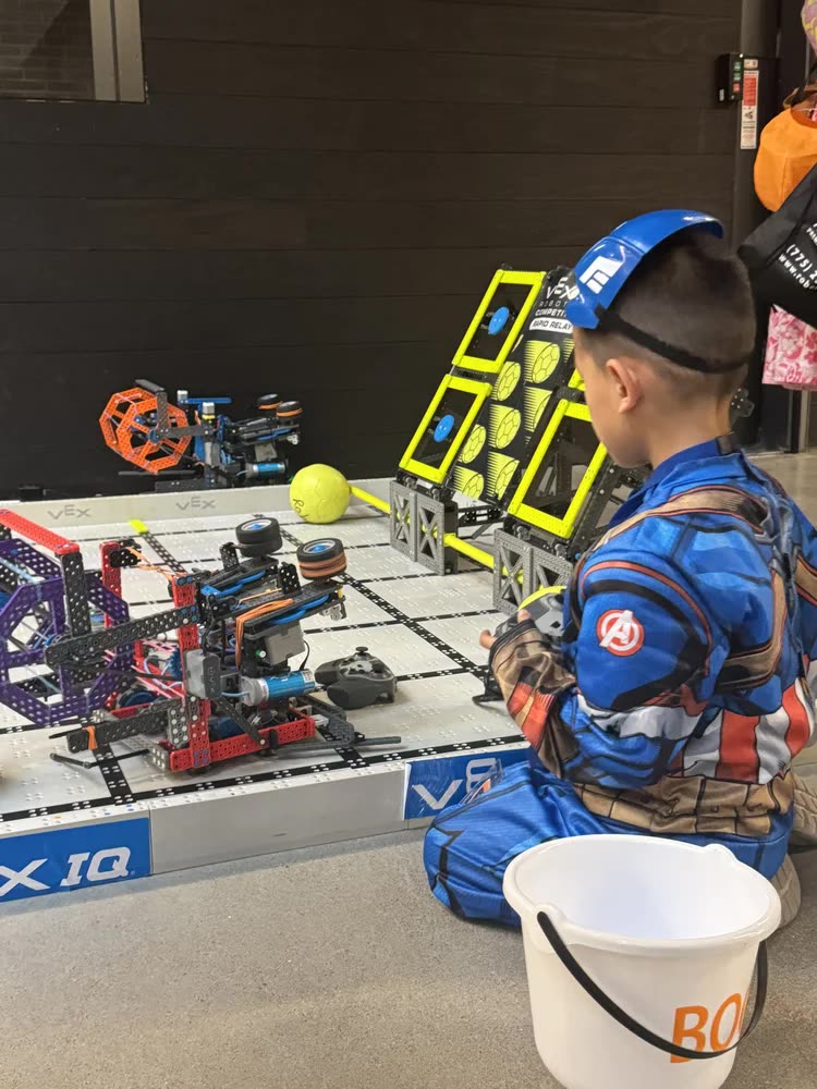A child in costume driving a VEX IQ robot at the Amazon workshop