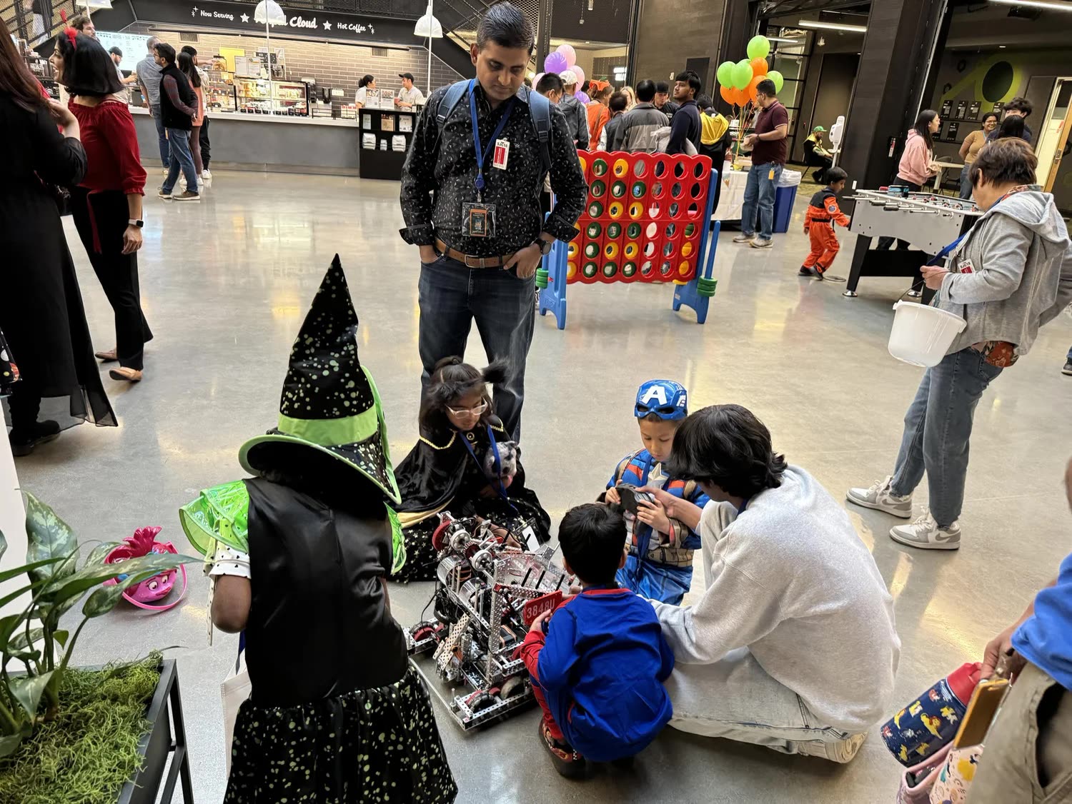 Children building and driving VEX robots on the floor at the AWS Bring Your Kid to Work robotics workshops