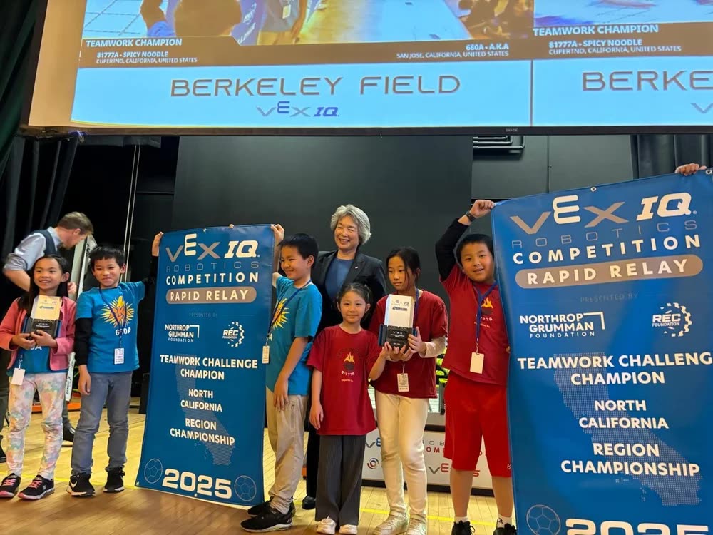 Dean Tsu-Jae King Liu with a champion team holding their Rapid Relay Teamwork Champion banners