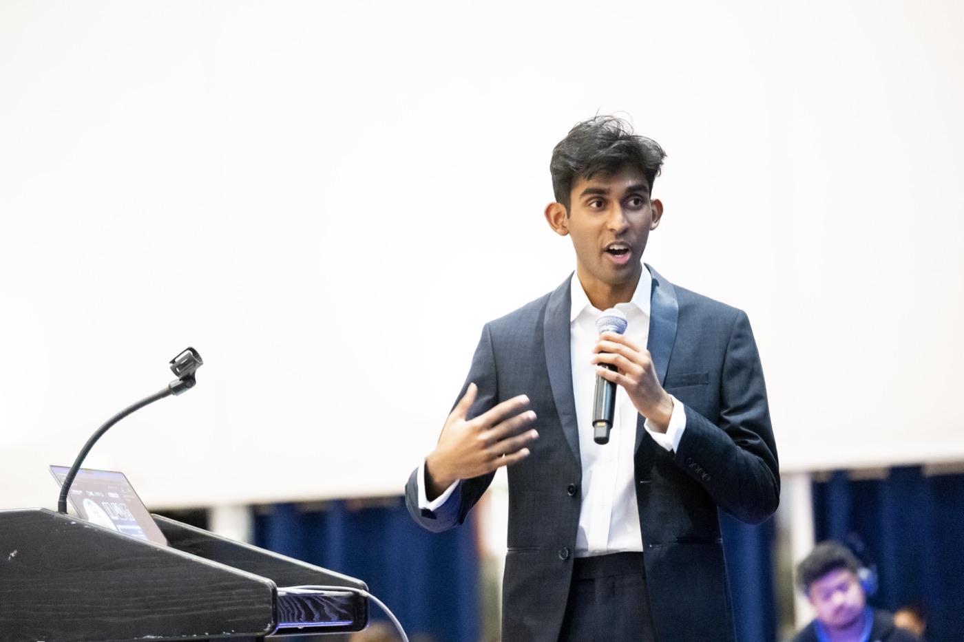Arya Sasikumar speaking into a microphone on stage