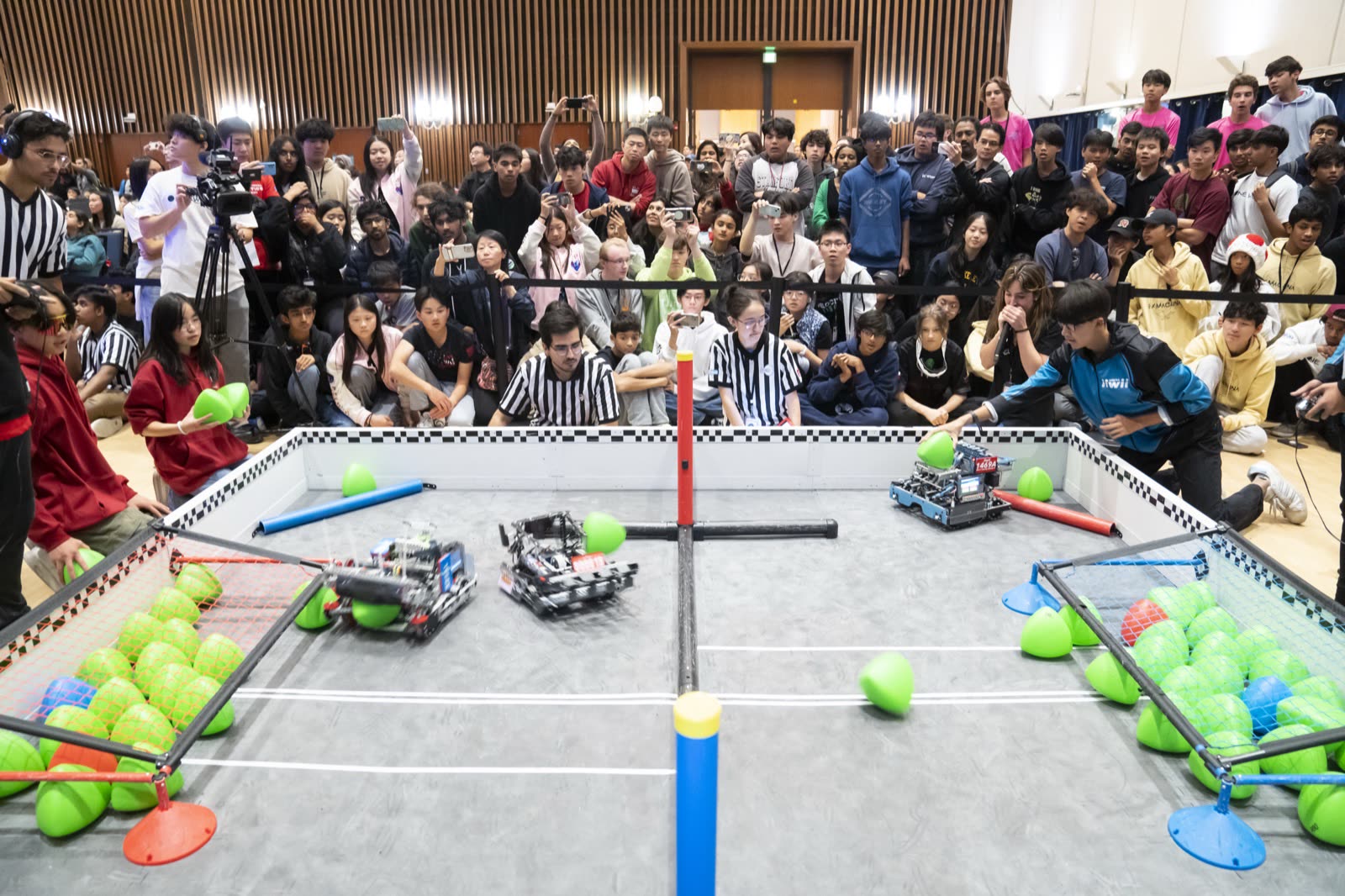 Two alliances competing on the field with the crowd behind