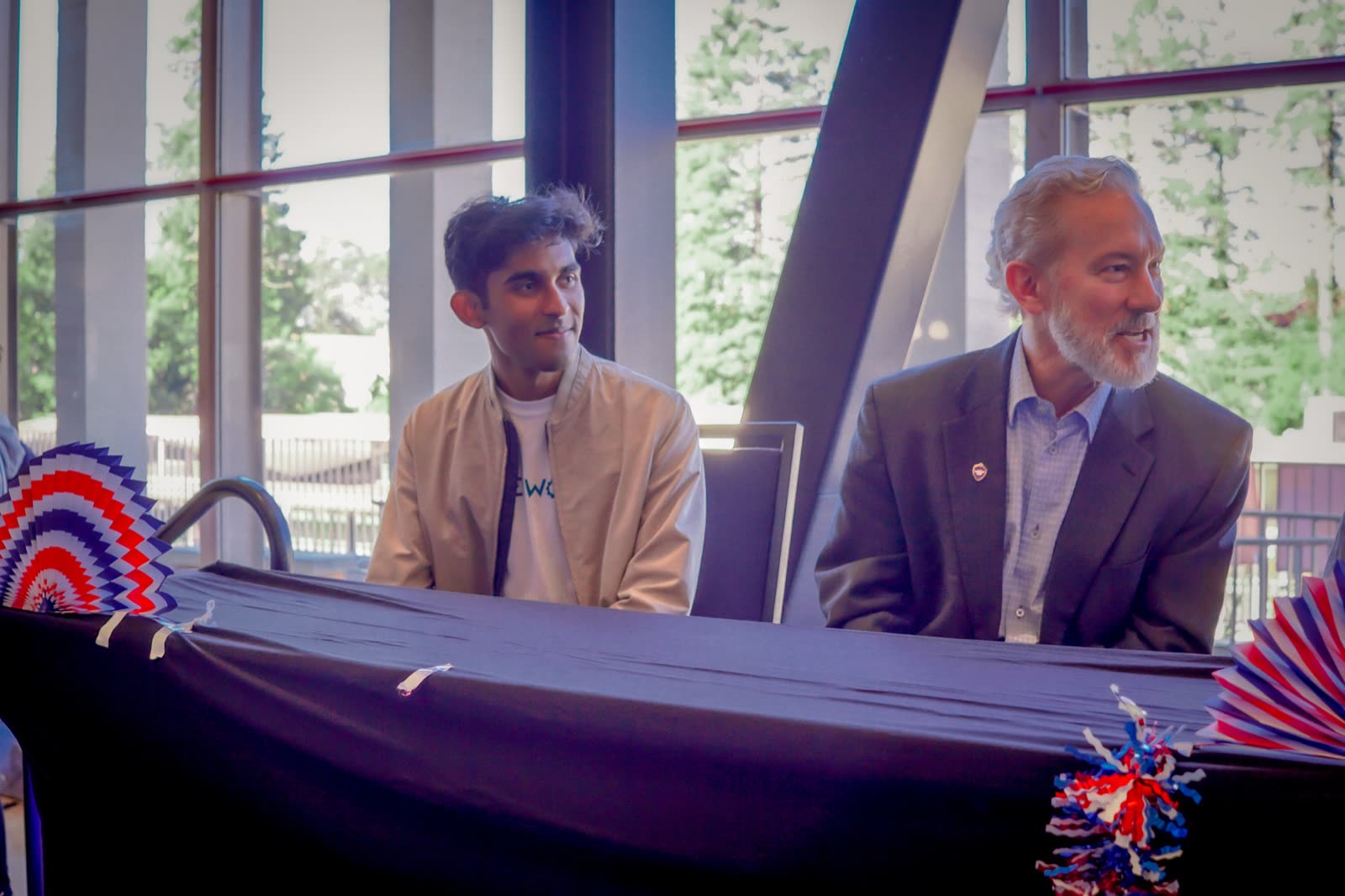 Arya Sasikumar seated beside Chancellor Rich Lyons at the head table