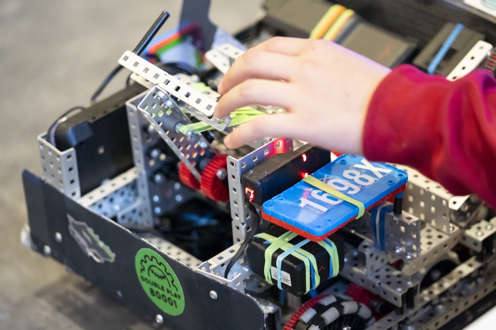 Close-up of hands adjusting a robot's intake mechanism