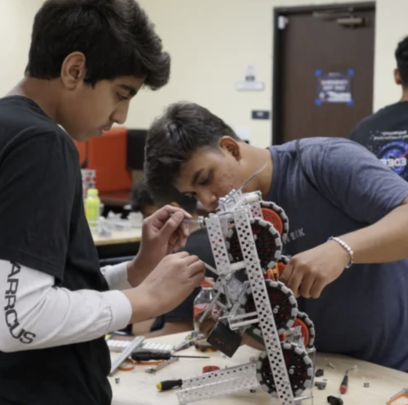 Two students assembling a competition robot during the Robot in 3 Days build